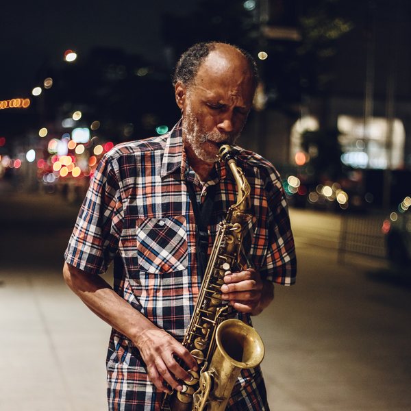 Daniel Carter playing saxophone on a New York street at night